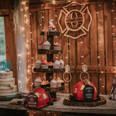Cupcakes with Bride's and Groom's cakes on table